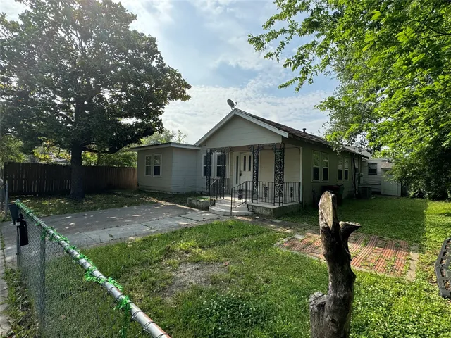 a front view of a house with garden and trees