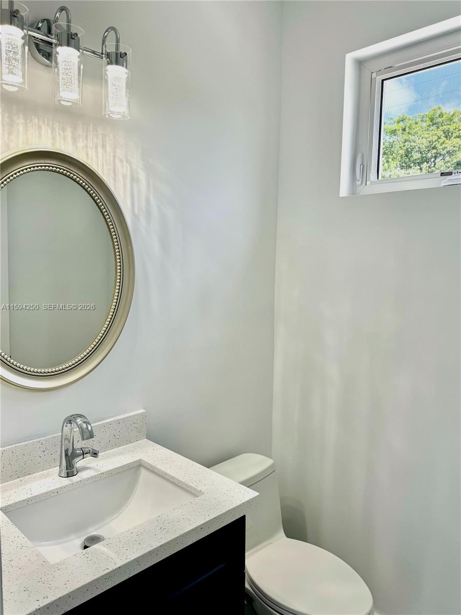 84 Coral Way Key Largo, FL 33037 - Photo 19 of 55 a bathroom with a toilet sink vanity and mirror