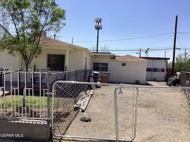 a view of a house with backyard and sitting area