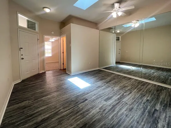 a view of an empty room with wooden floor