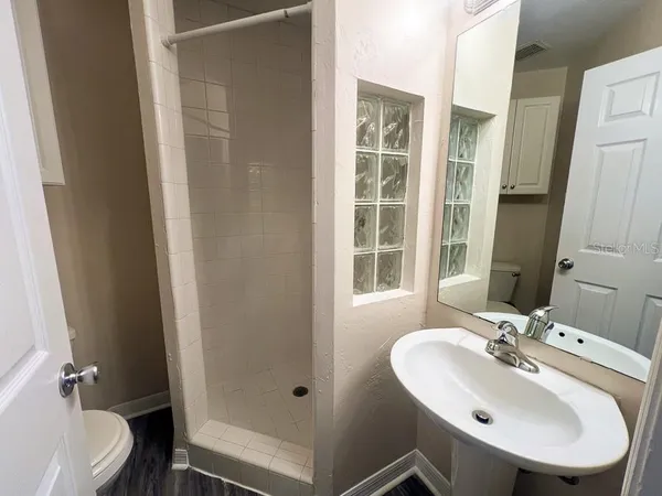 a bathroom with a sink a toilet and shower