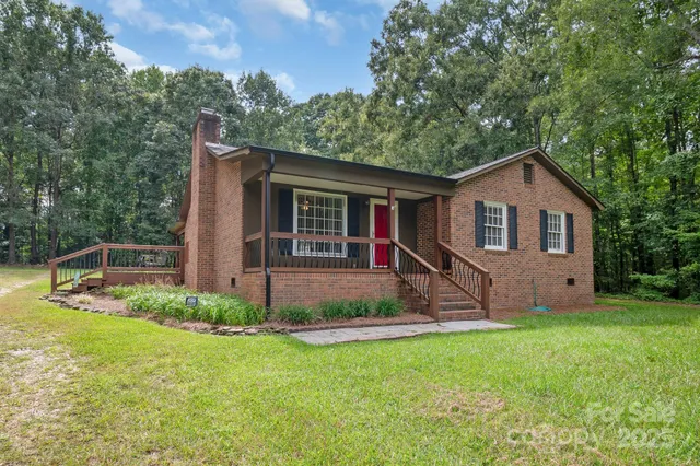 a view of a house with backyard and a tree