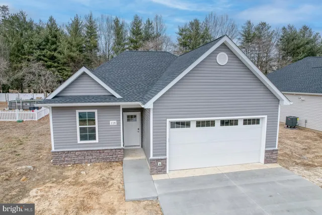 a view of a house with a yard and trees in the background