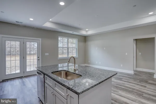 a kitchen with stainless steel appliances granite countertop a sink window and cabinets