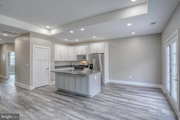 a kitchen with stainless steel appliances a refrigerator and a stove top oven