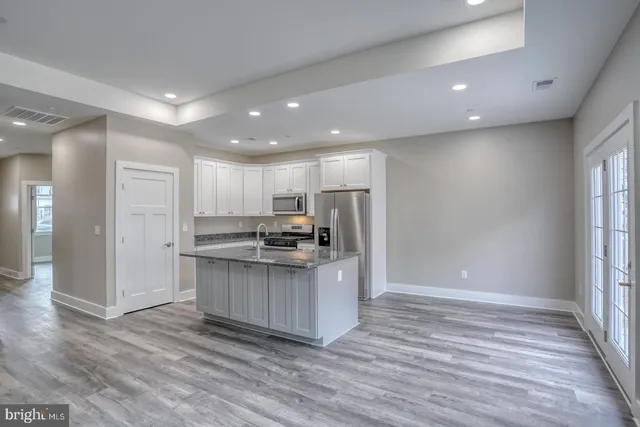 a kitchen with stainless steel appliances a refrigerator and a stove top oven