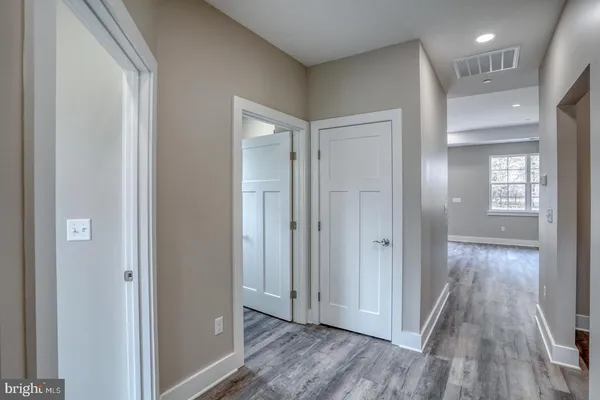 a view of a hallway with wooden floor