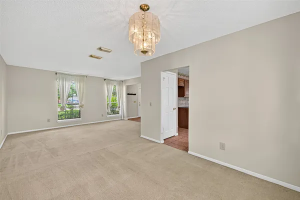 an empty room with windows and chandelier