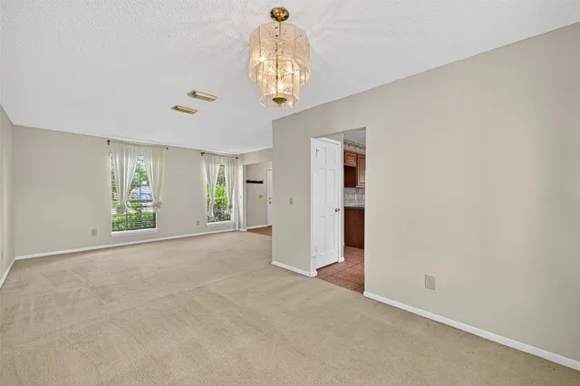 an empty room with windows and chandelier