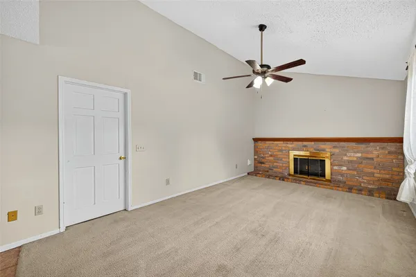an empty room with ceiling fan and window