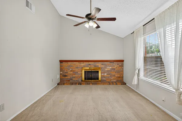 a view of a livingroom with a fireplace and window