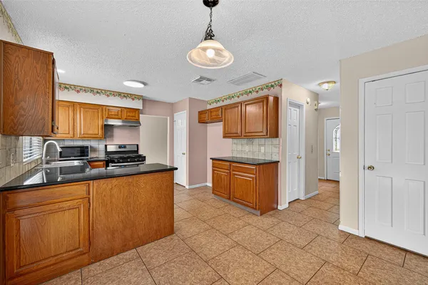 a large kitchen with stainless steel appliances granite countertop a stove and a sink