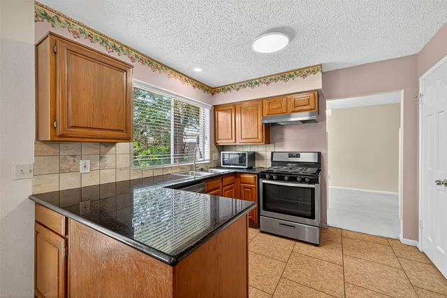 a kitchen with stainless steel appliances a stove sink and cabinets