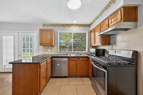 a kitchen with stainless steel appliances granite countertop a stove and a sink
