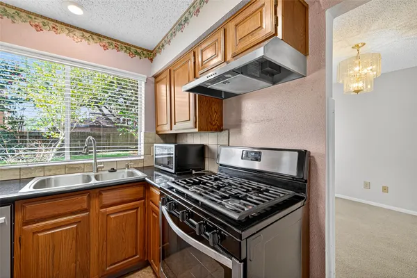 a kitchen with stainless steel appliances granite countertop a sink stove and refrigerator