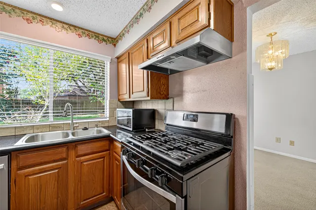 a kitchen with stainless steel appliances granite countertop a sink stove and refrigerator