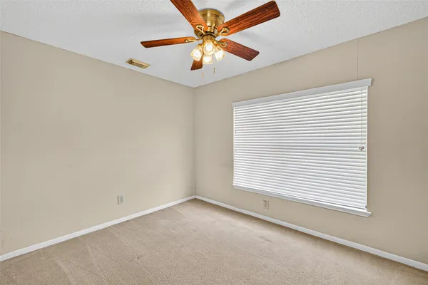 an empty room with closet and a chandelier fan