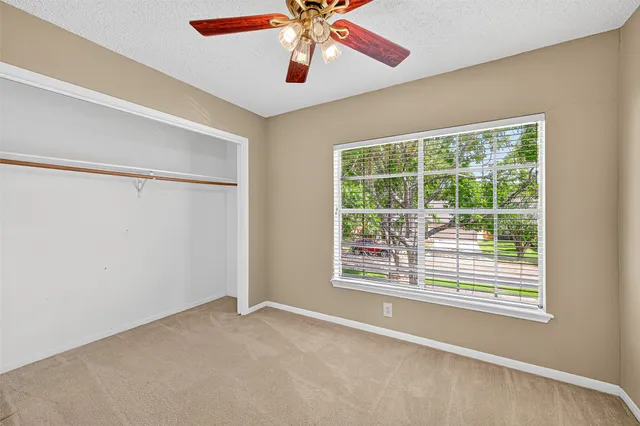 an empty room with a chandelier fan