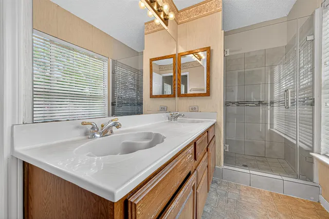 a bathroom with a granite countertop sink and a large mirror