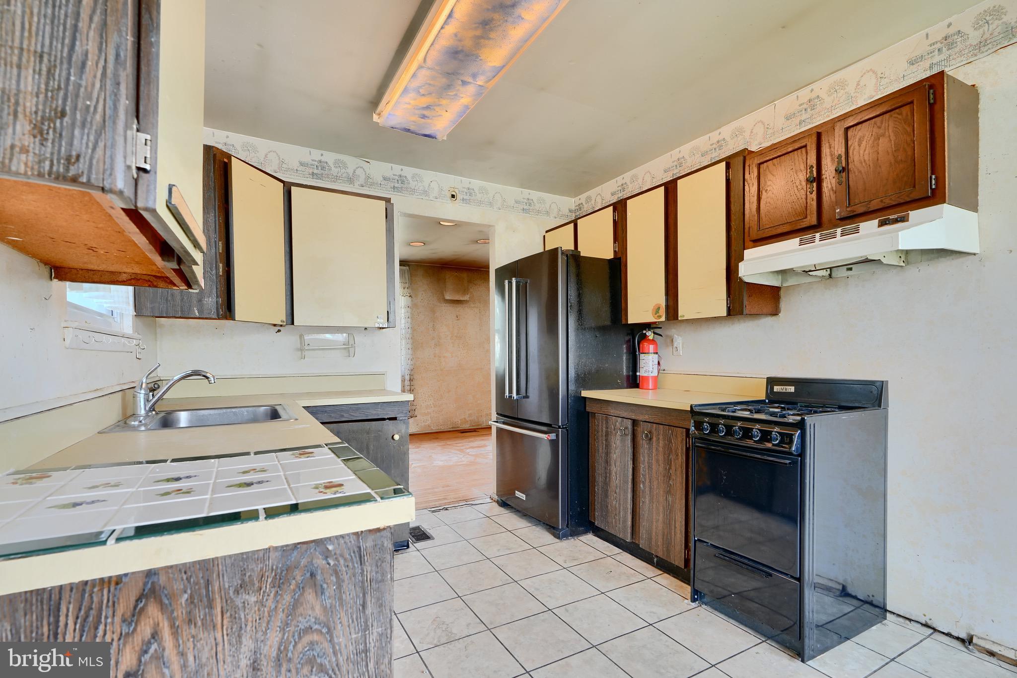 3902 Winlee Road Randallstown, MD 21133 - Photo 13 of 44 a kitchen with stainless steel appliances granite countertop a stove a sink and a microwave
