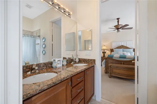 a bathroom with a granite countertop sink a mirror and shower