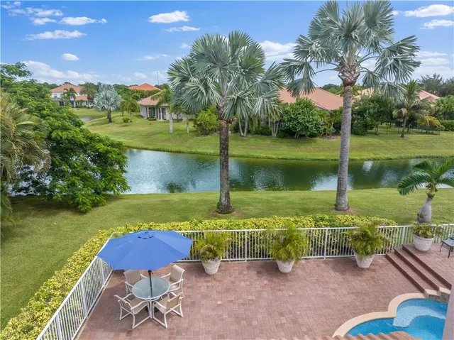a view of a lake with a yard swimming pool and outdoor seating
