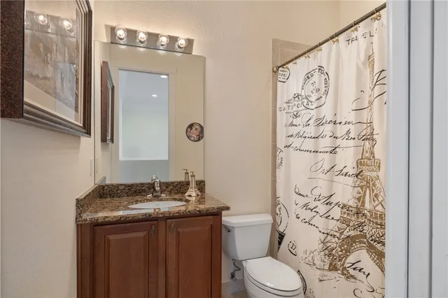 a bathroom with a granite countertop sink toilet and shower