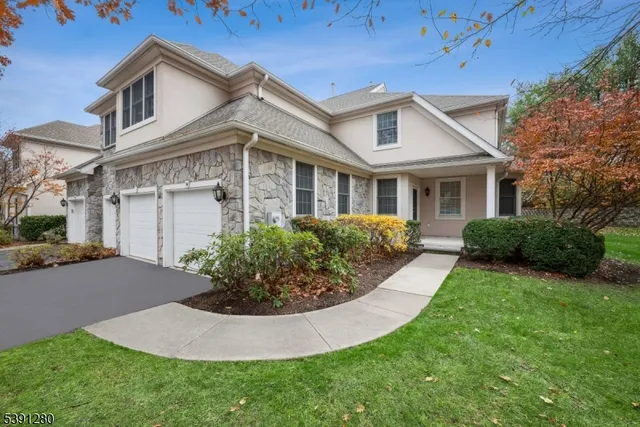 a view of a white house next to a yard with potted plants