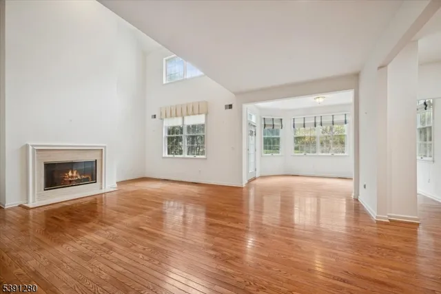 wooden floor fireplace and windows in an empty room