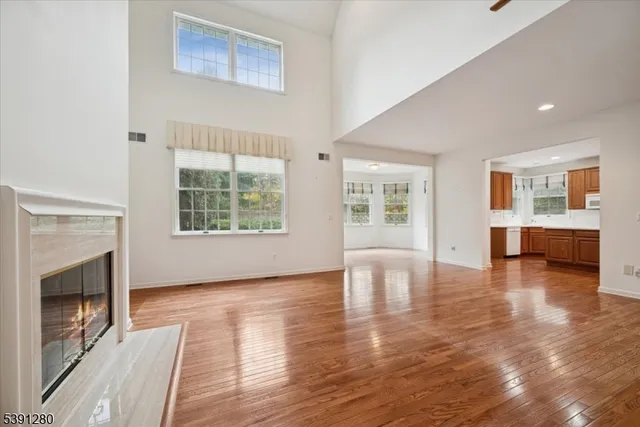 a view of an empty room with window and wooden floor