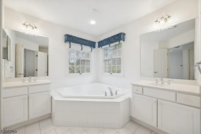 a bathroom with a tub sink and mirror