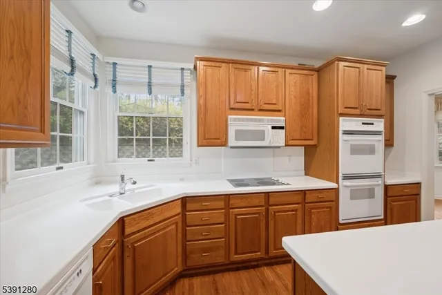 a kitchen with stainless steel appliances a sink cabinets and wooden floor