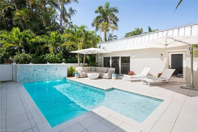 a view of a house with backyard and sitting area