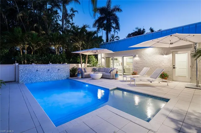a living room with patio furniture and a potted plants