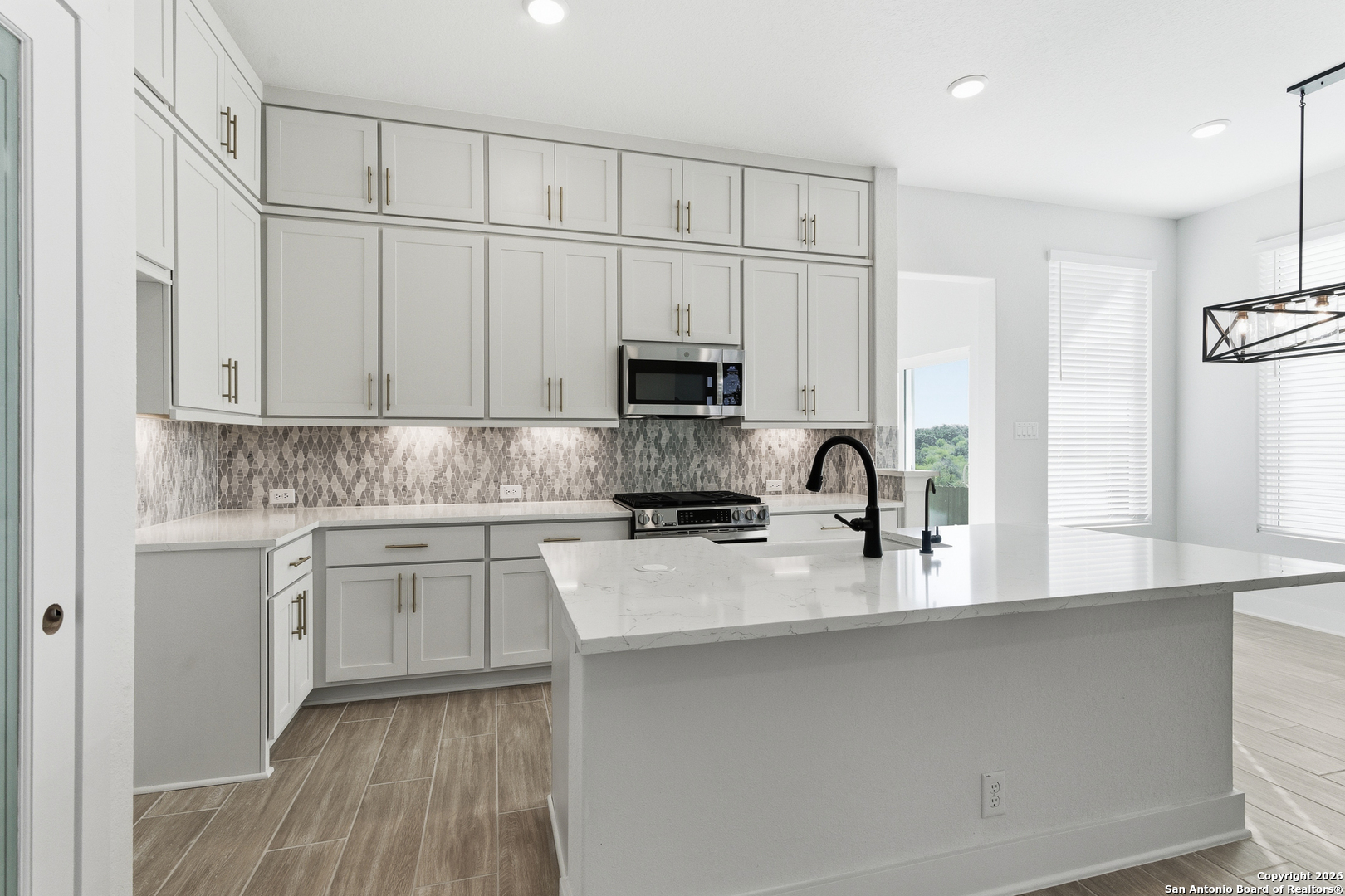 20675 Huebner Road, Unit 527 San Antonio, TX 78258 - Photo 14 of 43 a kitchen with granite countertop white cabinets and a stove top oven