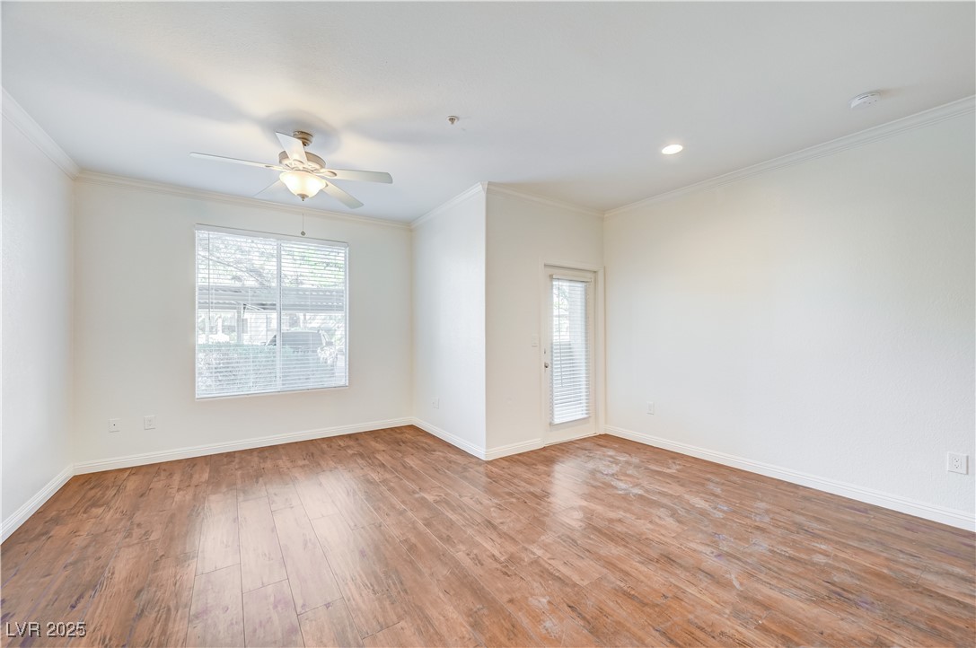 Unfurnished room with plenty of natural light, crown molding, light wood-style flooring, and ceiling fan