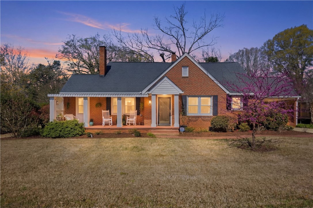 310 Retreat Street Westminster, SC 29693 - Photo 4 of 46 This charming brick residence features a welcoming porch, lush landscaping, and a well-maintained lawn.