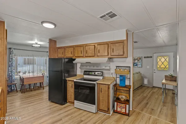 a kitchen with a stove a refrigerator and wooden floor