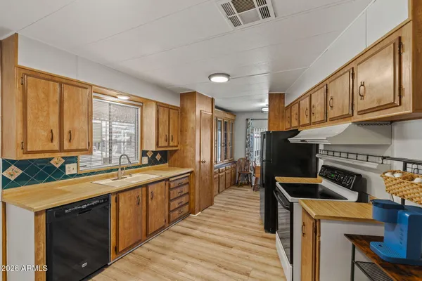 a kitchen with a sink a counter top space and stainless steel appliances