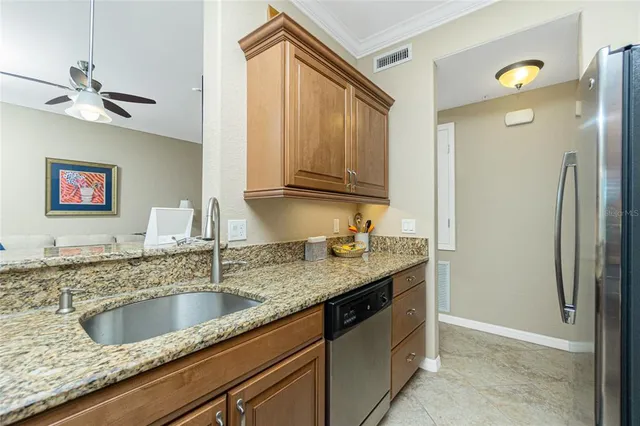 a kitchen with stainless steel appliances granite countertop a sink and a refrigerator