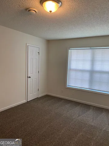 a view of a house with a small yard and wooden fence