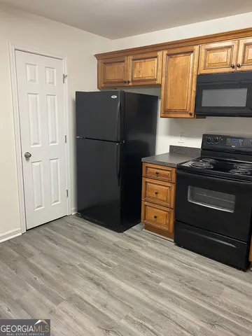 a kitchen with granite countertop a stove a sink and a microwave
