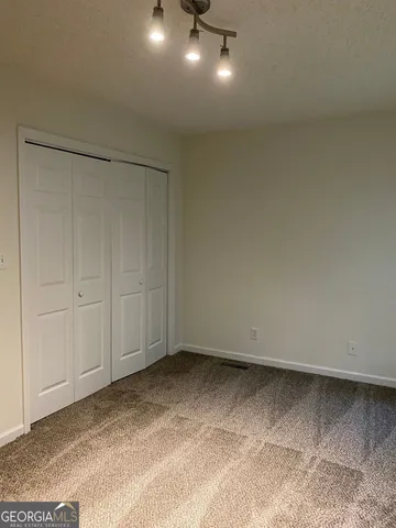 a bathroom with a granite countertop toilet sink and mirror