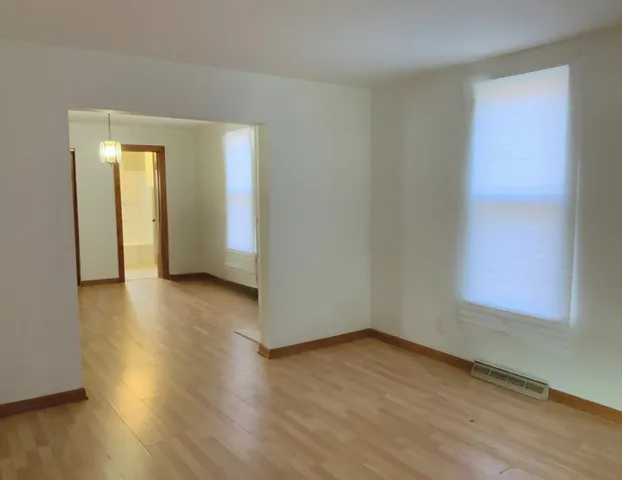 a view of a room with wooden floor and windows