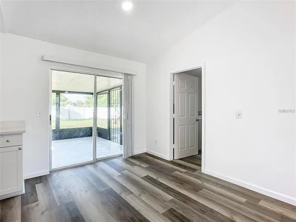 a kitchen with a white wooden cabinets and window