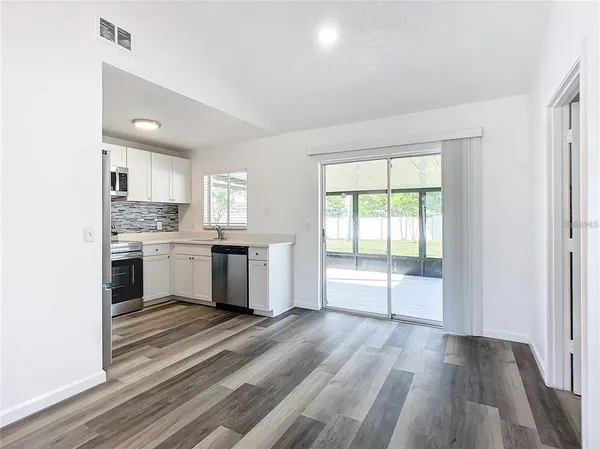 a kitchen with stainless steel appliances kitchen island granite countertop a refrigerator and a stove top oven