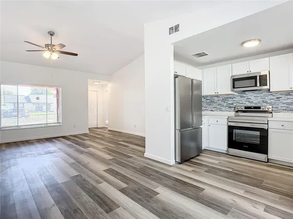 a kitchen with cabinets stainless steel appliances a sink and a window