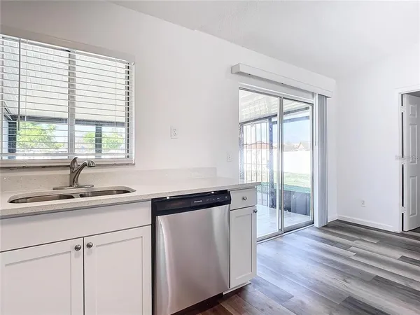 a view of empty room with window and wooden floor