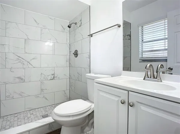 an empty room with a window and a ceiling fan