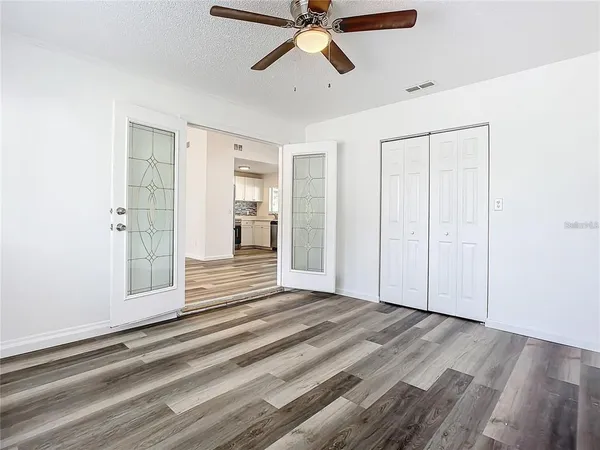 a view of empty room with wooden floor